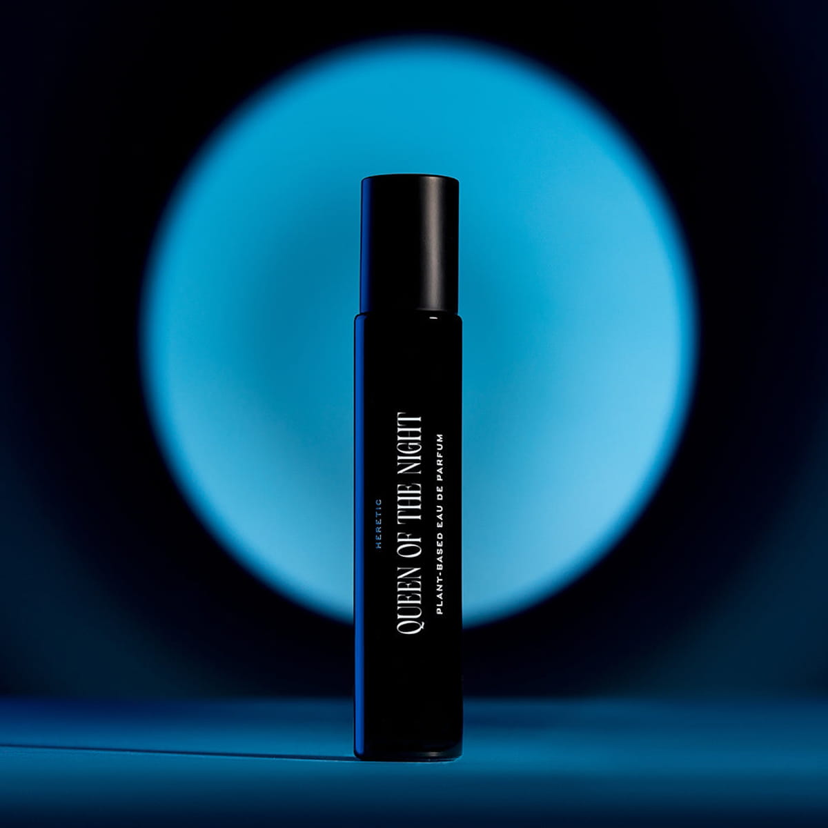 Heretic Parfum Queen of the Night Eau de Parfum (15 ml) - product shown in front of a blue circle of light. 