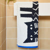 Donna Wilson Limited Lazy Cat Hand Towel (1 pc) shown folded and hanging on towel bar