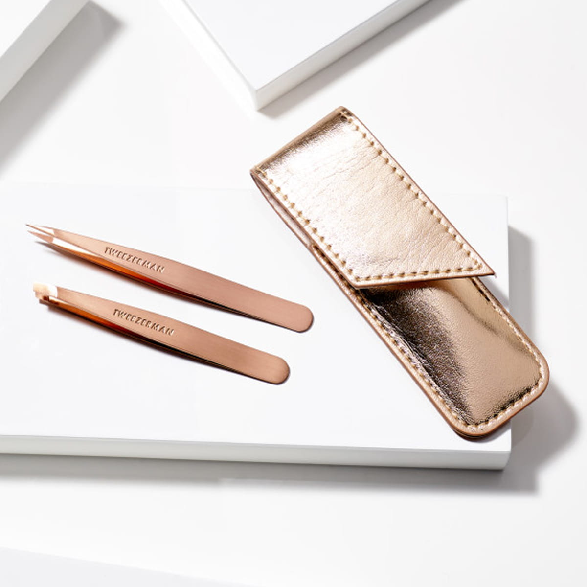 Tweezerman Petite Tweezer Set - Rose Gold (3 pcs) - product shown on white table.