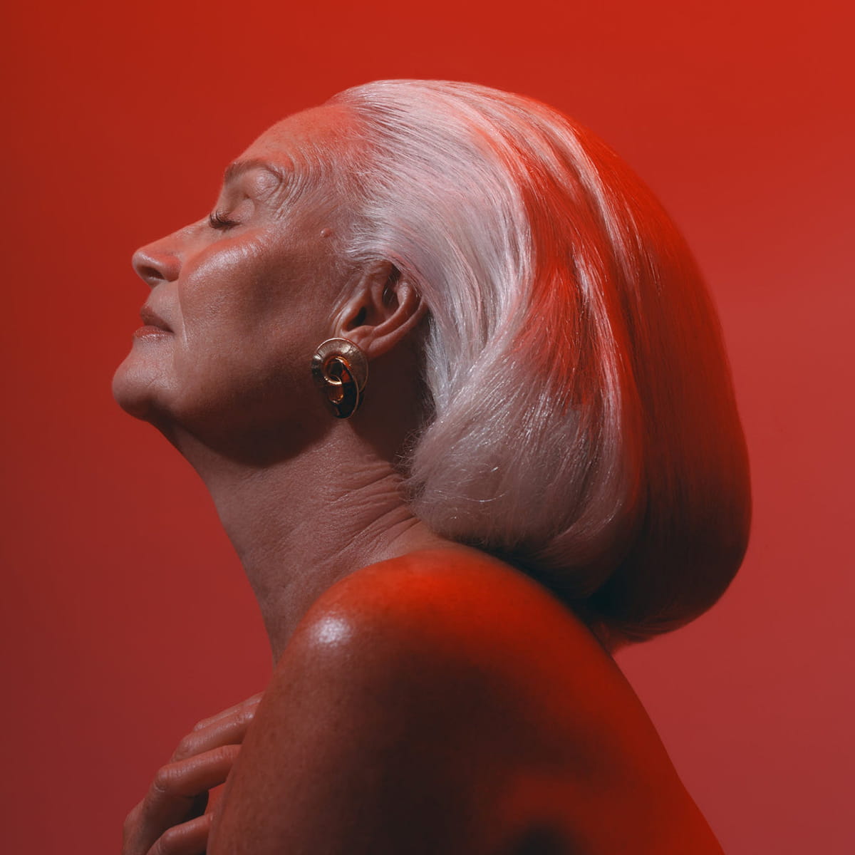 Sangre de Fruta Botanical Hair Elixir - Garden of Earthly Delights (200 ml) - model shown on red background. 