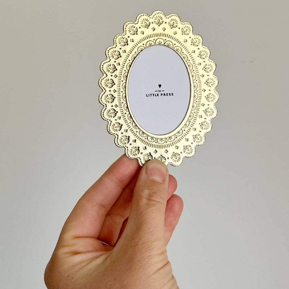 The Little Press Faux Tin Oval Frame - Gold (1 pc) - product shown being held in front of grey background.