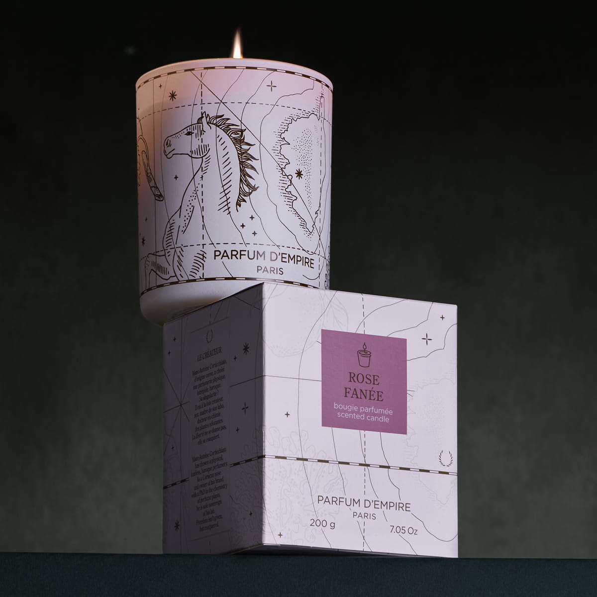 Parfum d'Empire Rose Fanee Scented Candle (200 g) shown lit sitting on box