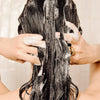 Rahua Voluminous Conditioner (275 ml) - product shown being lathered in model's hair. 