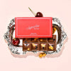 Superfine New York Cherry Chunky Milk Chocolate Bar (1.76 oz) - product shown on a decorative tray with cherries. 