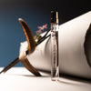 Lifestyle shot of Morn to Dusk Eau de Parfum Spray (10 ml) - product shown in front of papers and flowers.