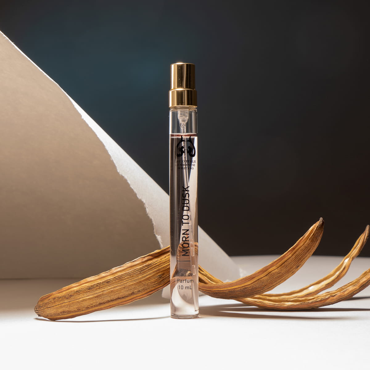 Lifestyle shot of Morn to Dusk Eau de Parfum Spray (10 ml) - product shown with paper in background.