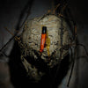 Heretic Parfum Beekeeper Eau de Parfum (15 ml) - product shown on a wasp nest with barbed wire in the background