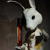 Heretic Parfum Fourteen Carrots Eau de Parfum (15 ml) - product shown being held by a rabbit doll. 
