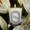 Diptyque Lys (Lily) Classic Candle (190 g) - product shown on top of lilies. 