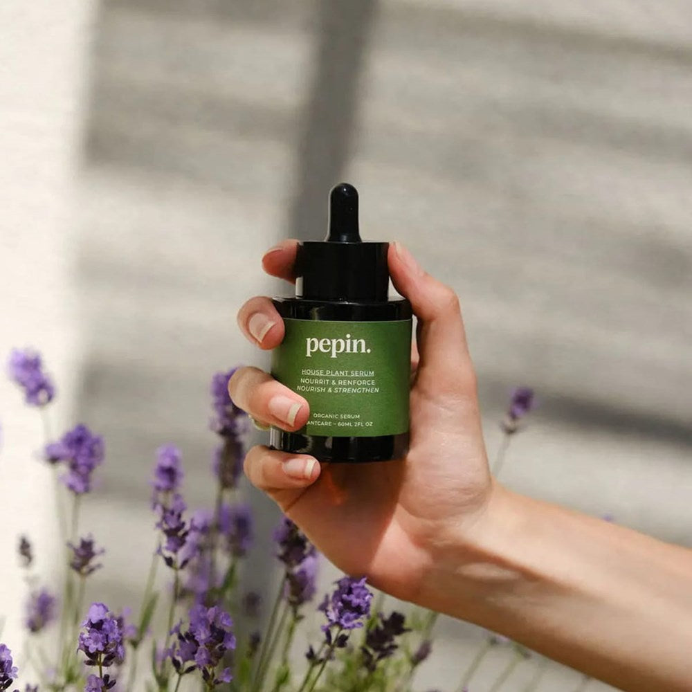 Pepin House Plant Serum (60 ml) - product shown being held in front of lavender. 