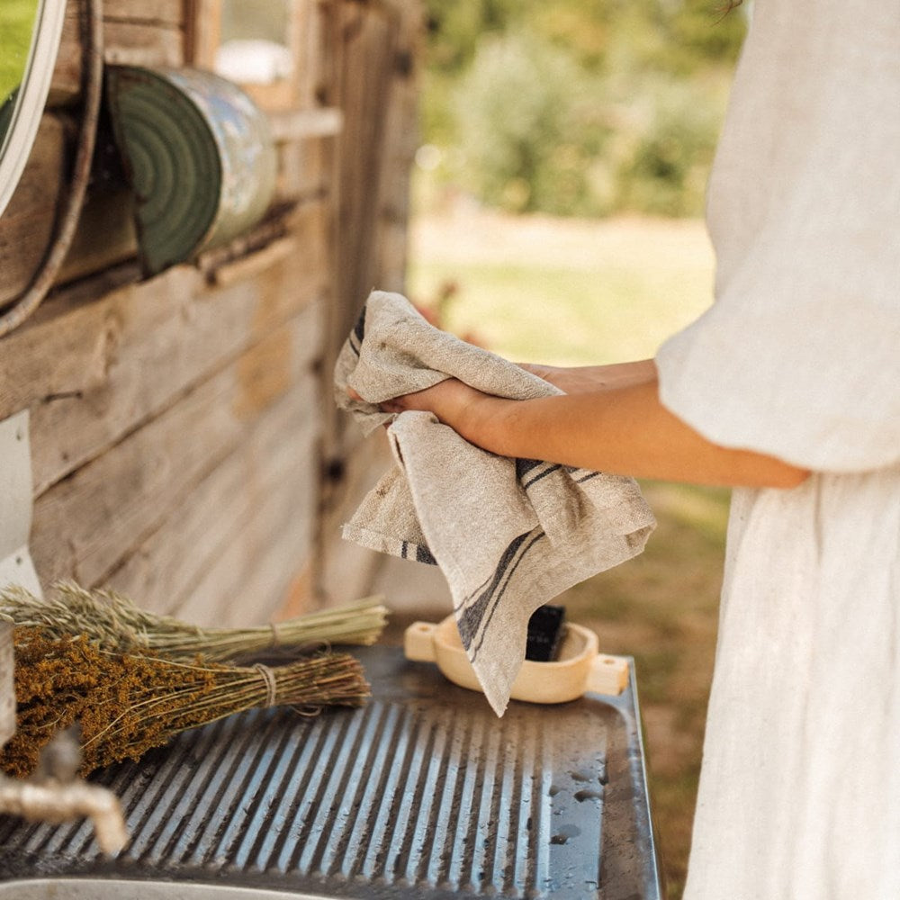 Linen Tales Linen Kitchen Towel - Vintage Blue Stripes (1 pc) - product shown being used to dry hands.