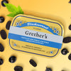 Lifestyle shot of Grether’s Pastilles Blackcurrant Tin - Classic (110 g) shown closed with pastilles and mint leaf in the background