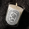 Diptyque Sesame Noir Classic Candle (190 g) - product shown in sesame seeds.