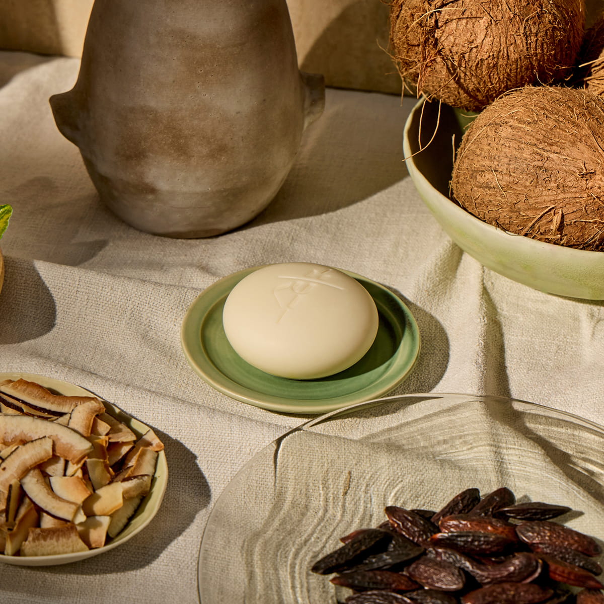 Kate McLeod Tonka Bean & Coconut Deep Moisturizing Lotion Bar (3.5 oz) - product shown on table with fruits. 