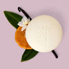 Kate McLeod Tangerine & Vanilla Deep Moisturizing Lotion Bar (3.5 oz) - product shown with ingredients on purple background. 