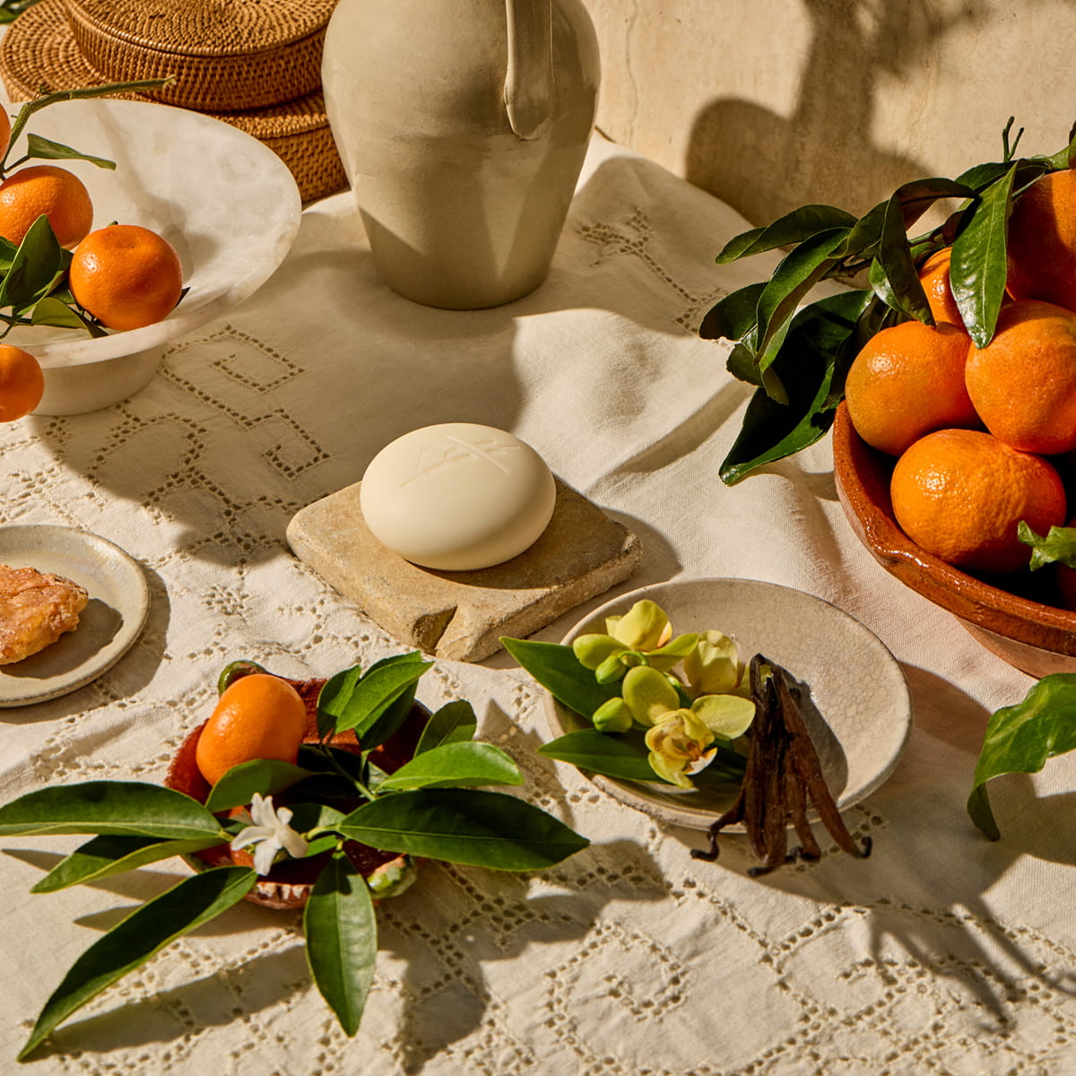 Kate McLeod Tangerine & Vanilla Deep Moisturizing Lotion Bar (3.5 oz) - product shown on table with tangerines and vanilla. 