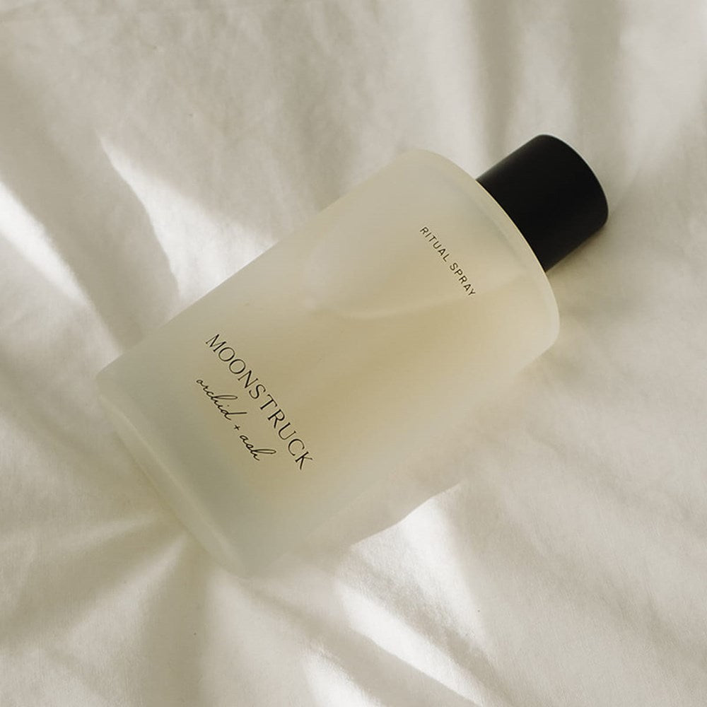 Orchid + Ash Moonstruck Ritual Spray (100 ml) on a soft beige fabric background