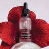 Yon-Ka Paris Bi-Serum Retinol-Like (30 ml)  - product shown in front in front of red flowers.
