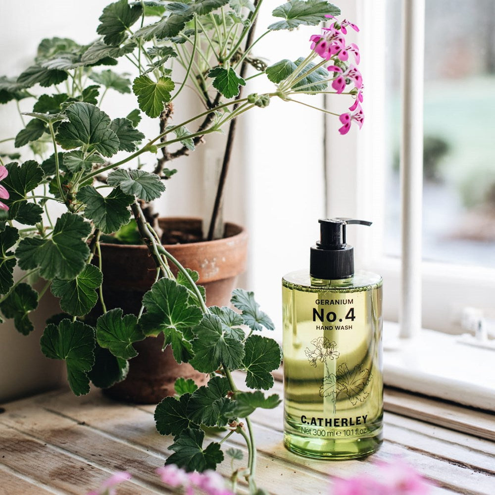 C.Atherley Geranium No.4 Hand Wash (300 ml) - product shown on wooden counter next to plant.