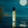 Heretic Parfum Jasmine Smoke Eau de Parfum (15 ml) - product shown on wet counter with a moon in a background. 