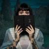 Heretic Parfum Rhubarb Thief Discovery Set (5 x 2 ml) - product shown being held by model on blue mountainous background.