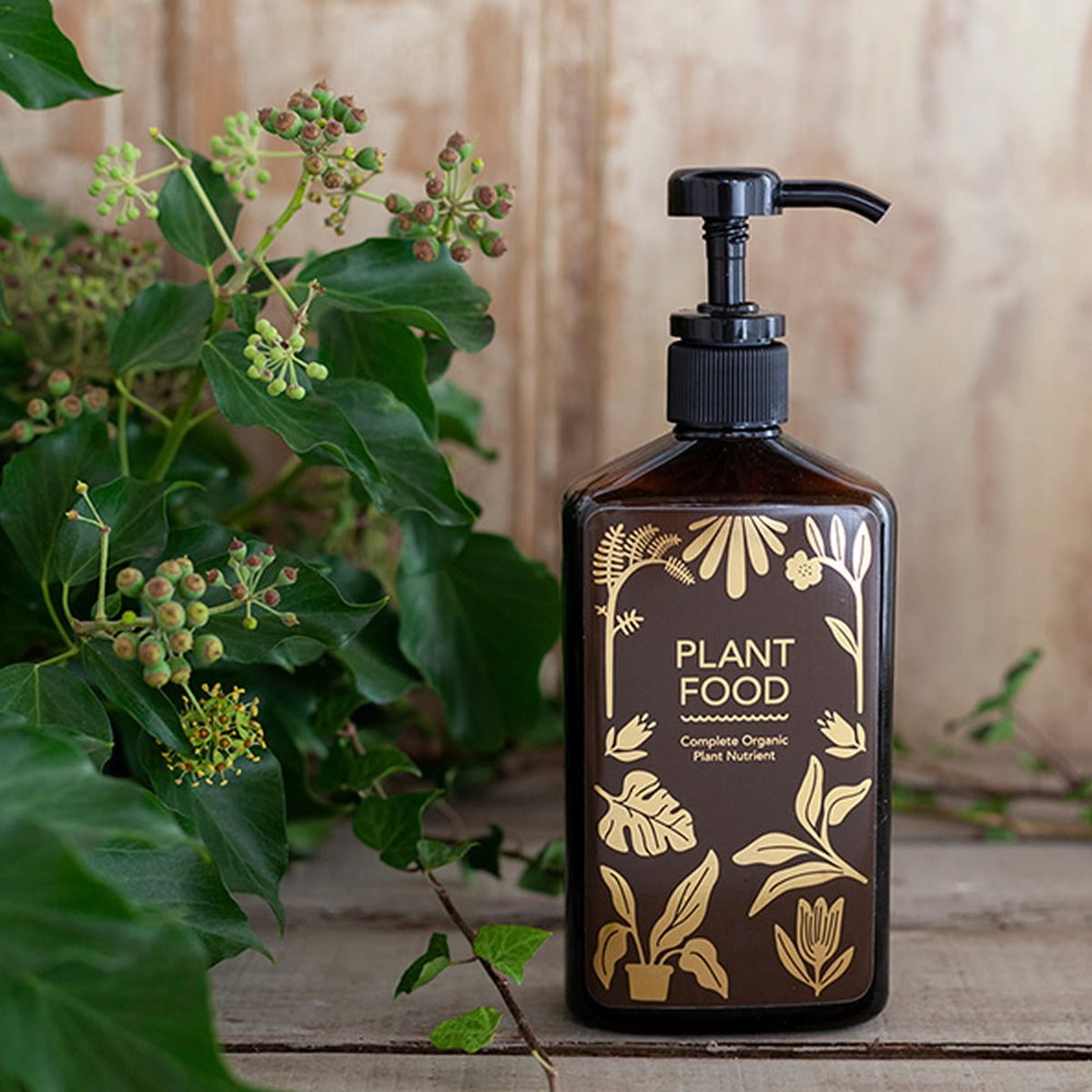 Botanopia Complete Organic Plant Food (450 ml) - product shown in front of plant. 