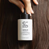 Cosmetics 27 Hair & Scalp Serum (50 ml) - product shown being held next to hair. 