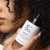 Cosmetics 27 Hair & Scalp Serum (50 ml) - product shown being held next to hair. 