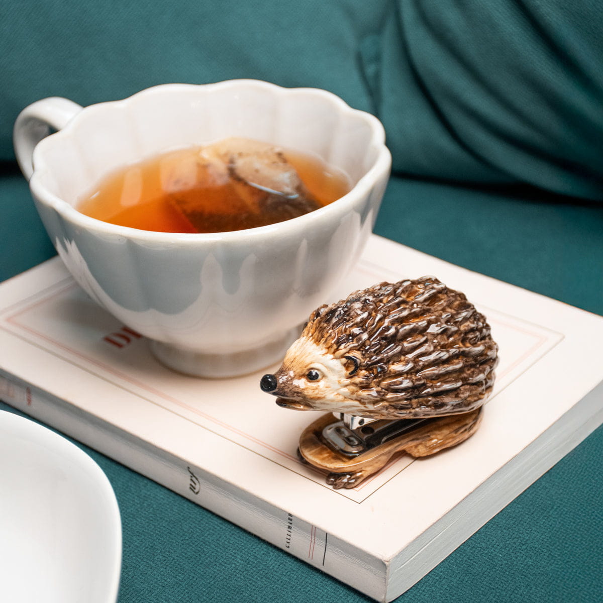 Nach Hedgehog Stapler (1 pc) - product shown on top of book and next to tea. 