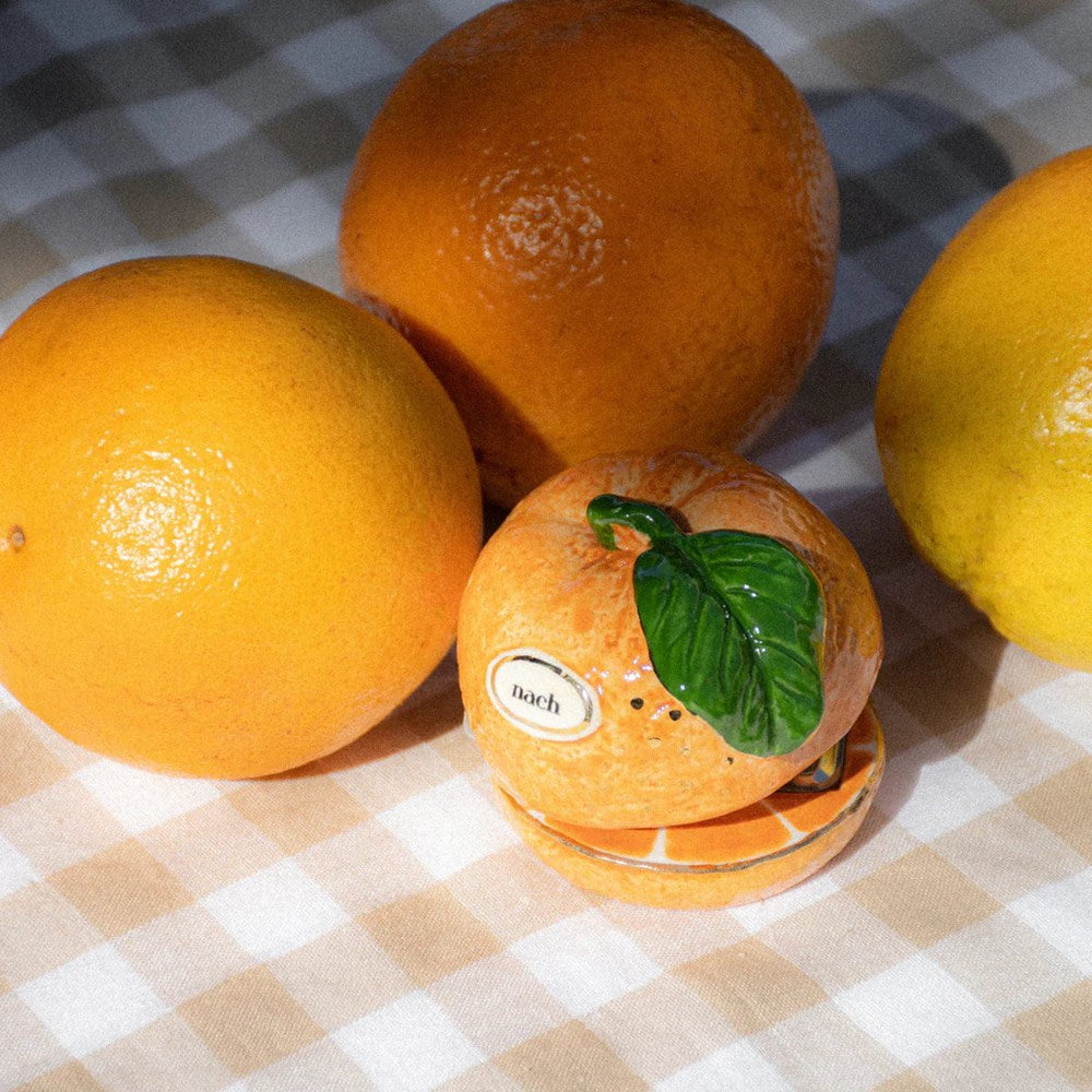 Nach Orange Stapler (1 pc) - product shown on gingham cloth next to other oranges.
