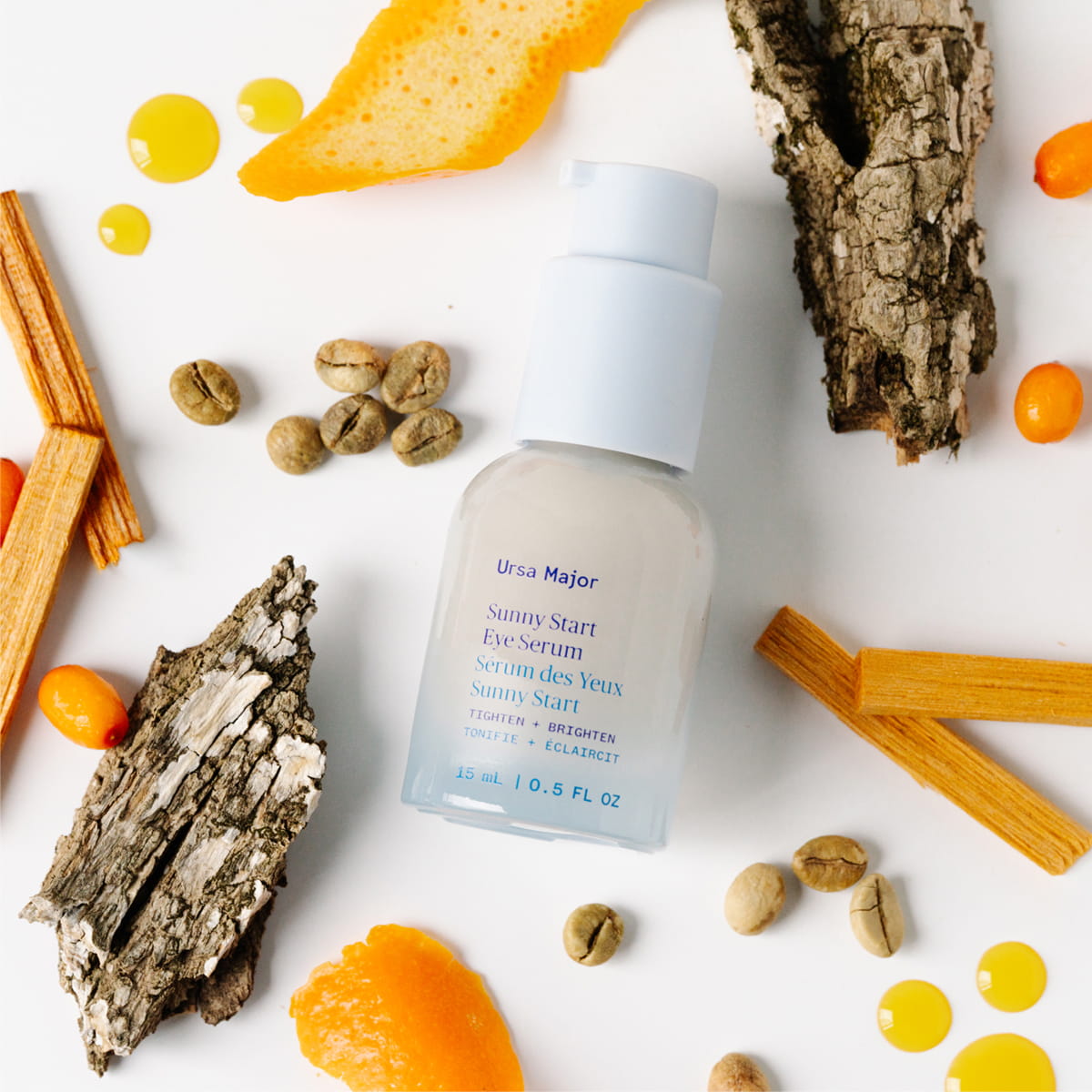 Ursa Major Sunny Start Eye Serum (0.5 oz) surrounded by natural elements on a white background