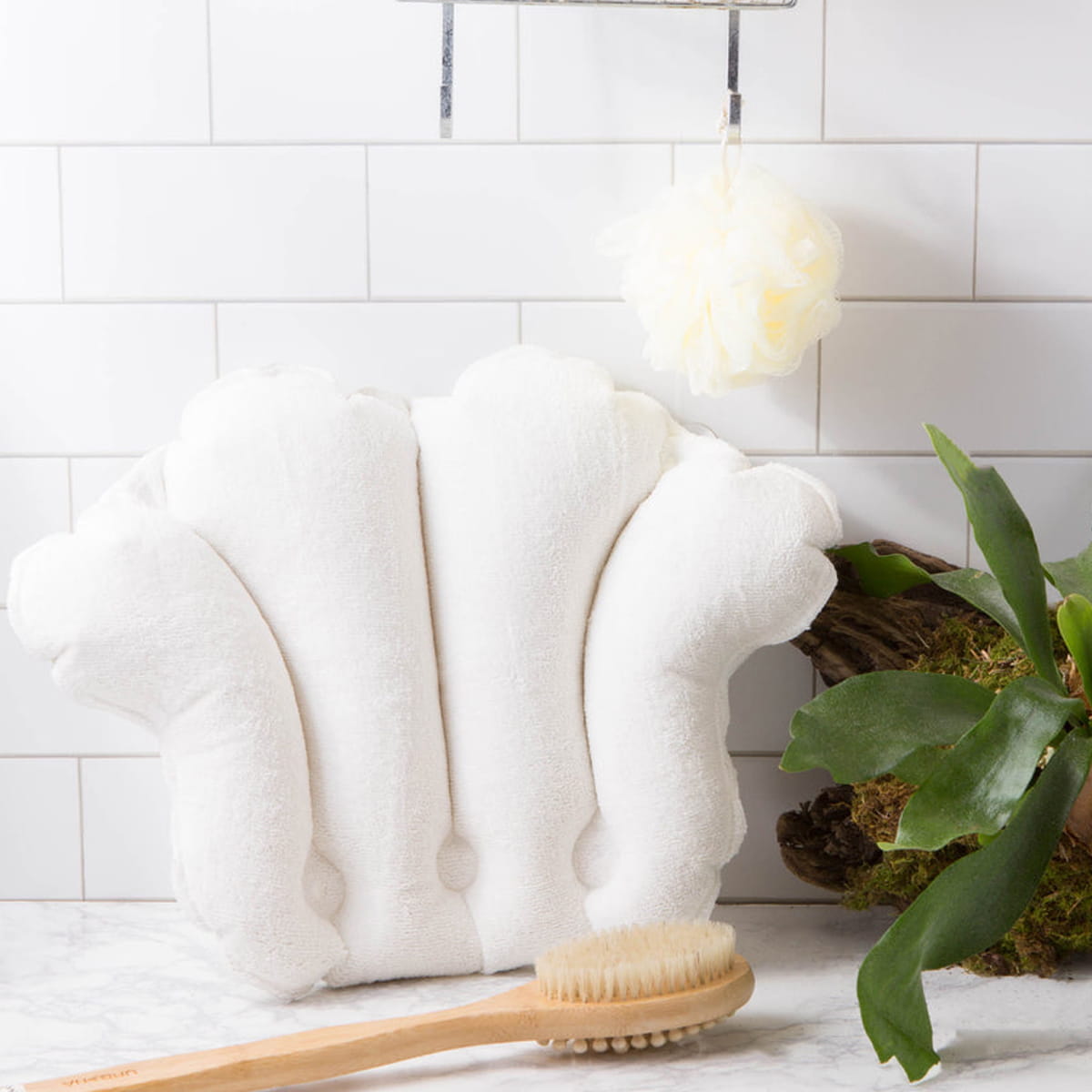 Urbana Spa Prive Microfibre Bath Pillow (1 pc) - product shown on marble counter next to misc. bath tools and plant. 