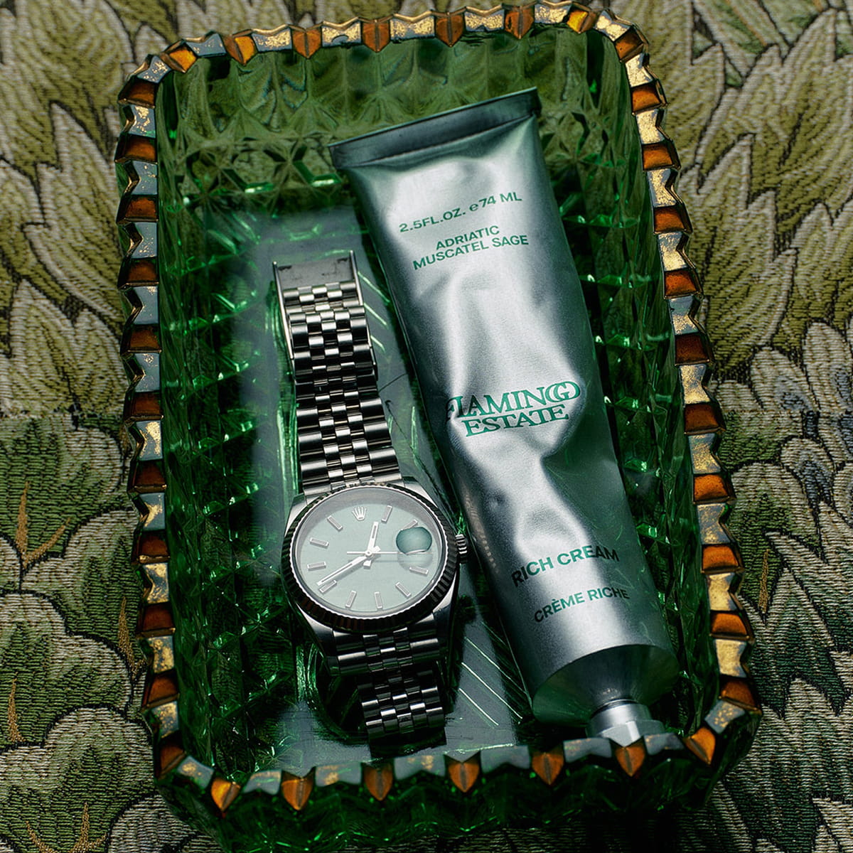 Flamingo Estate Adriatic Muscatel Sage Rich Cream (74 ml) - product shown in glass dish next to watch. 