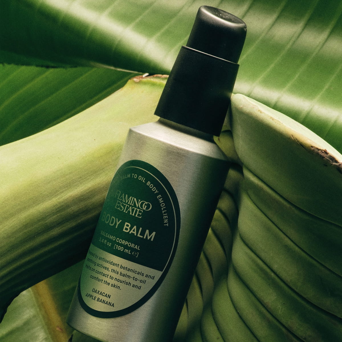 Flamingo Estate Oaxacan Apple Banana Body Balm (100 ml) - product shown on leaf.
