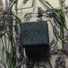 Flamingo Estate Lavender Activated Charcoal Soap Brick (340 g) - product shown with lavender flavors behind it.