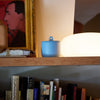 ROEN Candles Hakone Scented Candle (8 oz) - product shown on wood shelf.