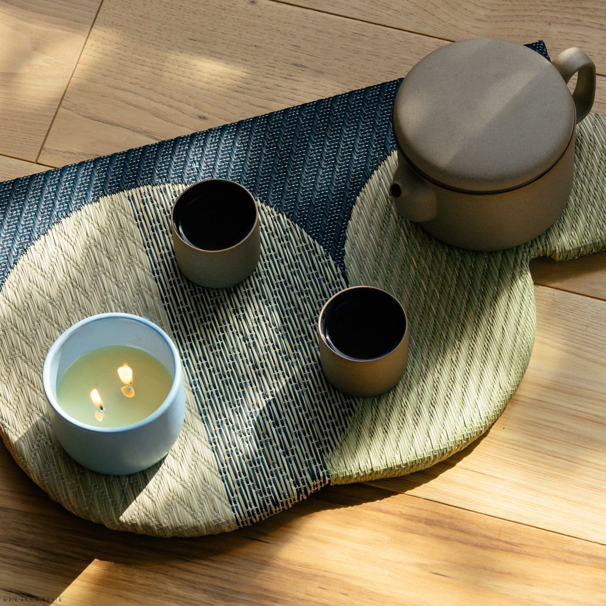 ROEN Candles Hakone Scented Candle (8 oz) - product shown on table mat with tea cups and tea kettle.