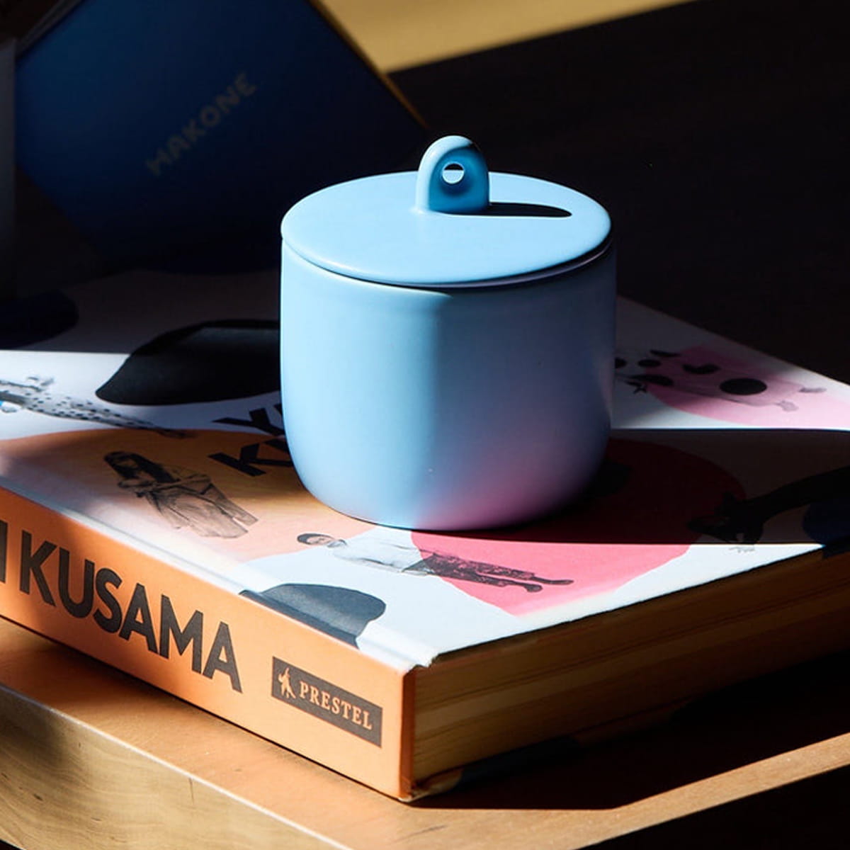 ROEN Candles Hakone Scented Candle (8 oz) - product shown on book. 