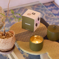 ROEN Candles Nakame Scented Candle (8 oz) - product shown on table lit next to packaging.