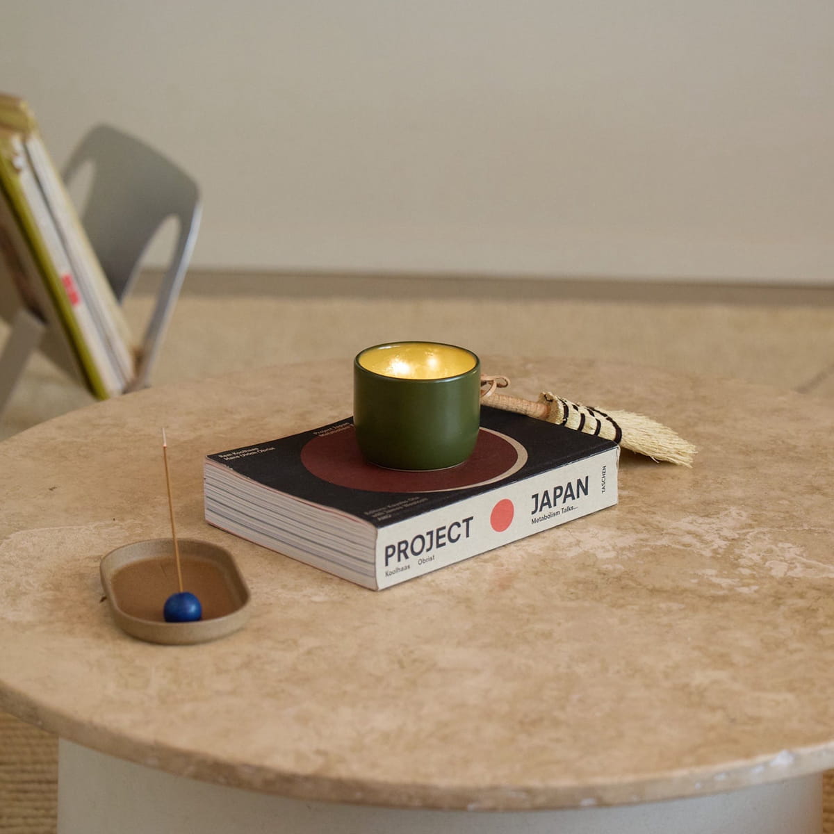 ROEN Candles Nakame Scented Candle (8 oz) - product shown lit and on top of book.