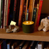 ROEN Candles Nakame Scented Candle (8 oz) - product shown lit on shelfing.