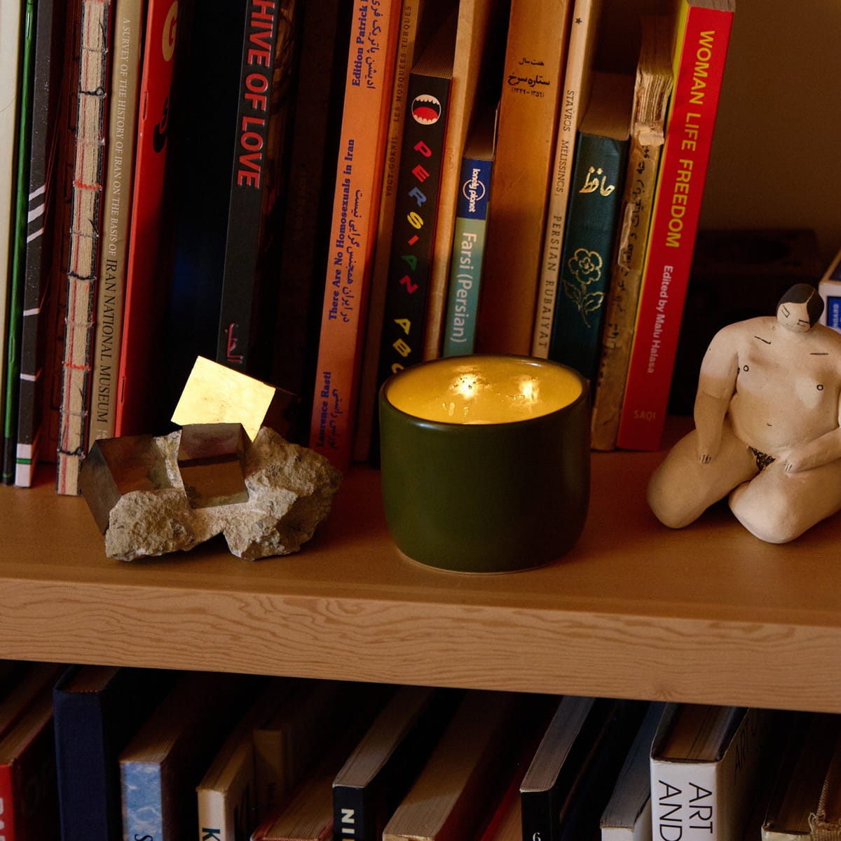 ROEN Candles Nakame Scented Candle (8 oz) - product shown lit on shelfing.
