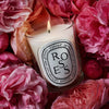 Diptyque Roses Classic Candle (190 g) - product shown in the middle of flowers. 