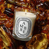 Diptyque Ambre (Amber) Classic Candle (190 g) - product shown o top of amber. 