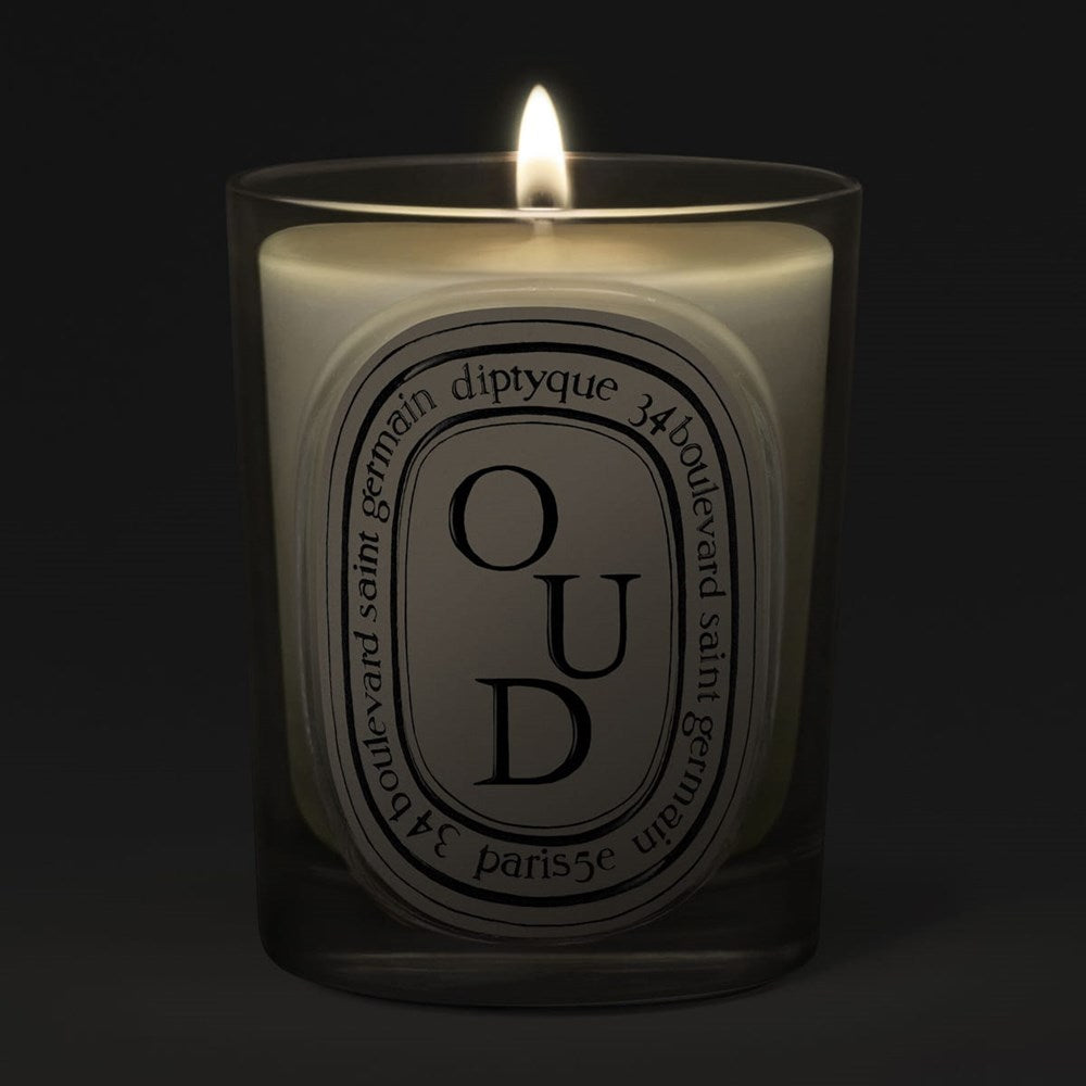 Diptyque Oud Classic Candle (190 g) - product shown lit on dark background. 