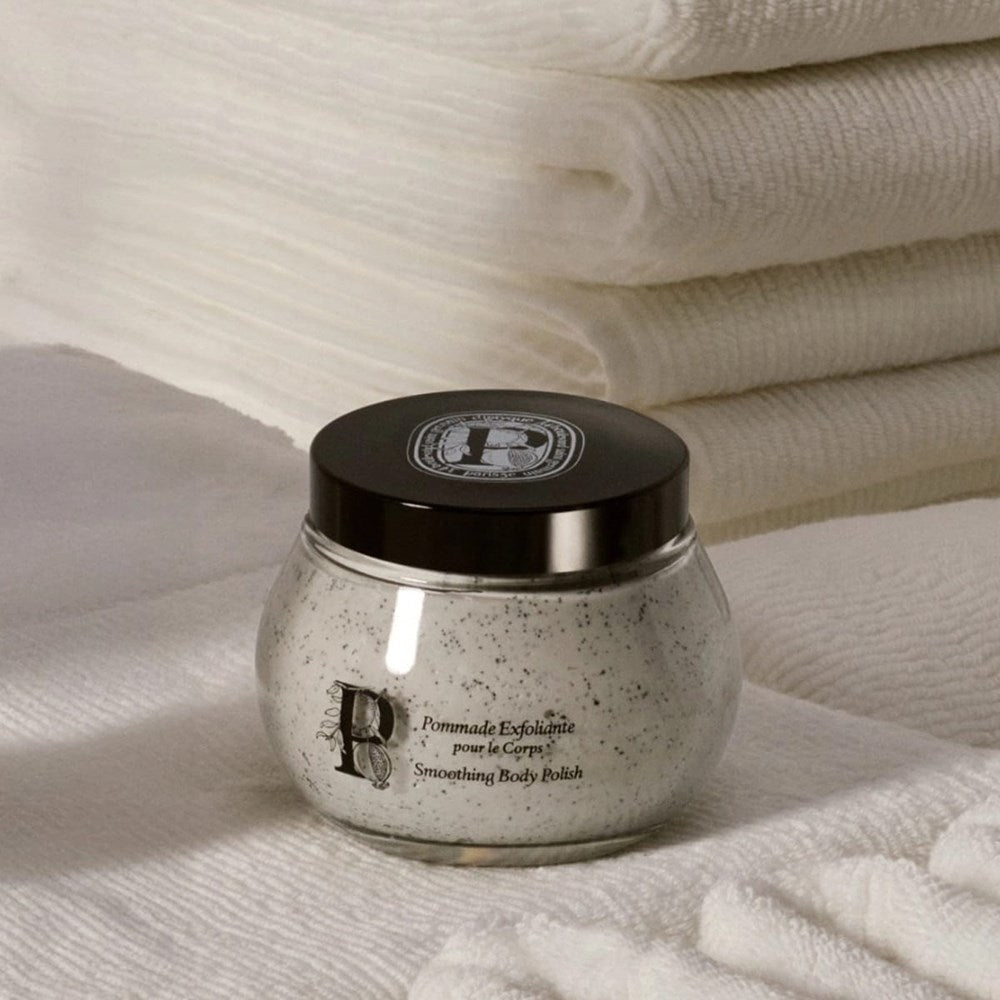 Diptyque Smoothing Body Polish (200 ml) - product shown on top of towels. 