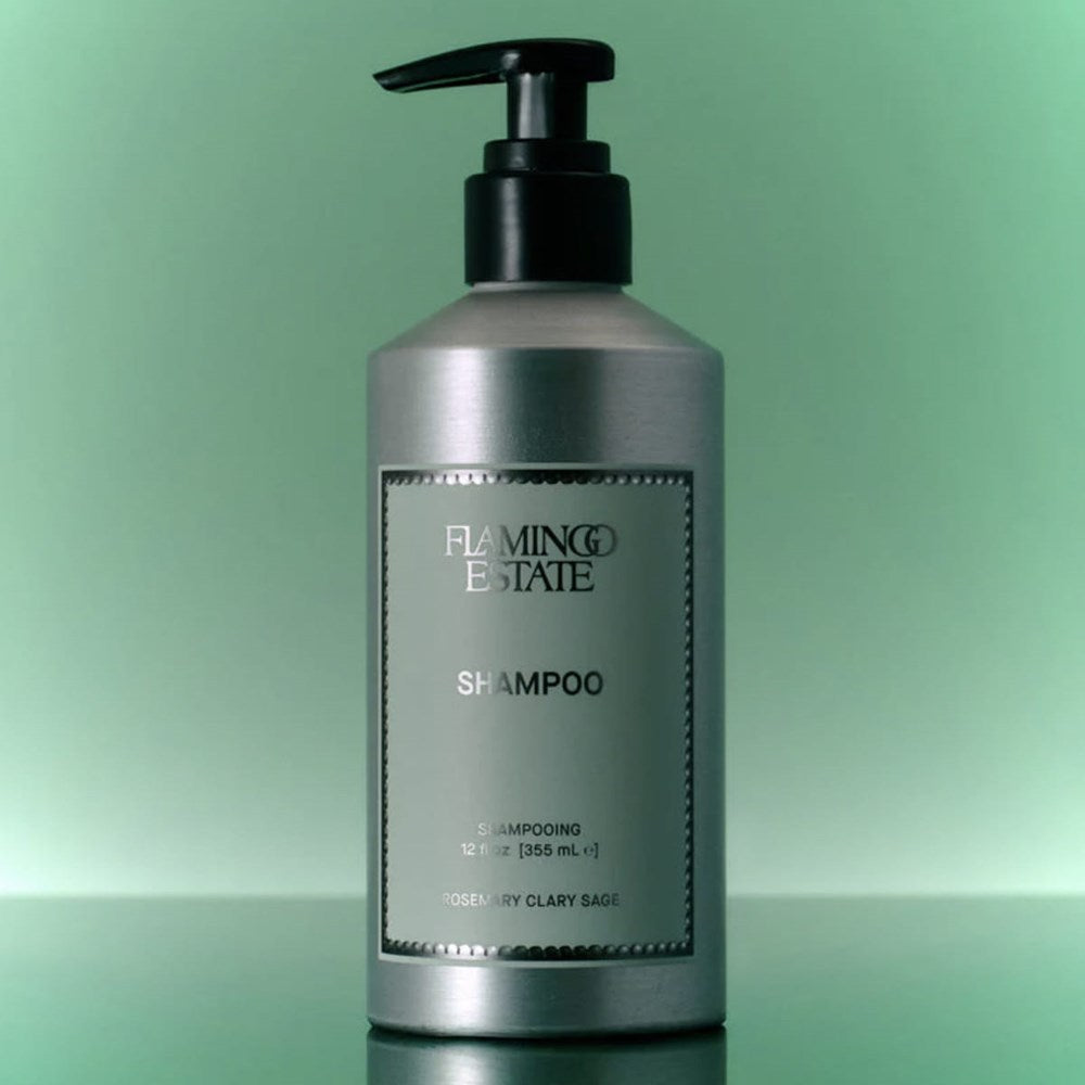Lifestyle shot of Flamingo Estate Rosemary Clary Sage Shampoo (355 ml) against a green background