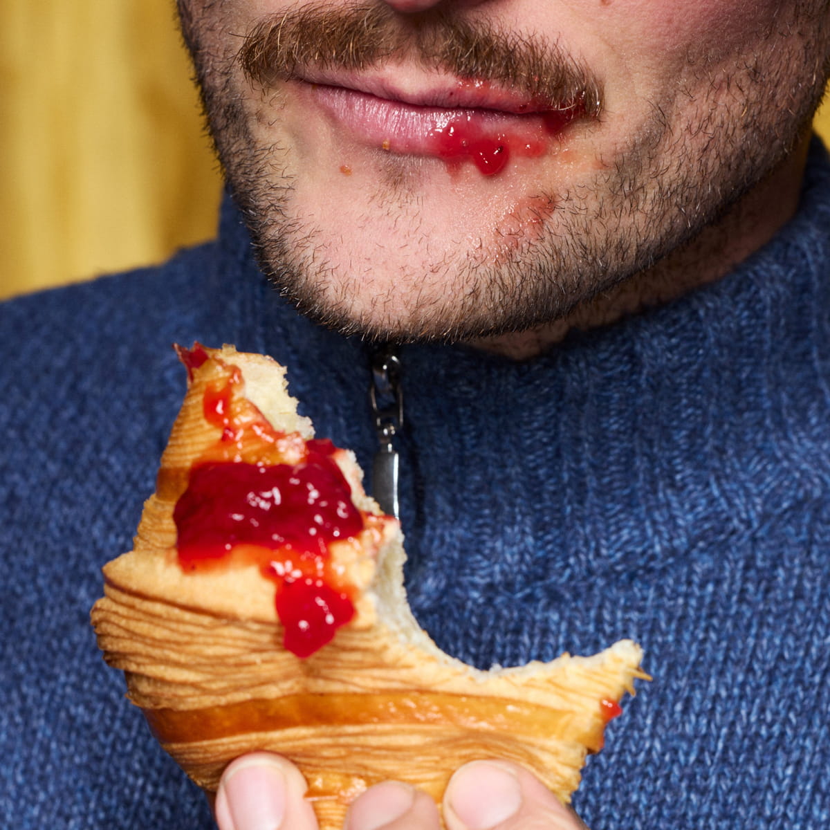 Sky High Farm Goods Strawberry Jam (8 oz) - product shown on croissant and model's mouth. 