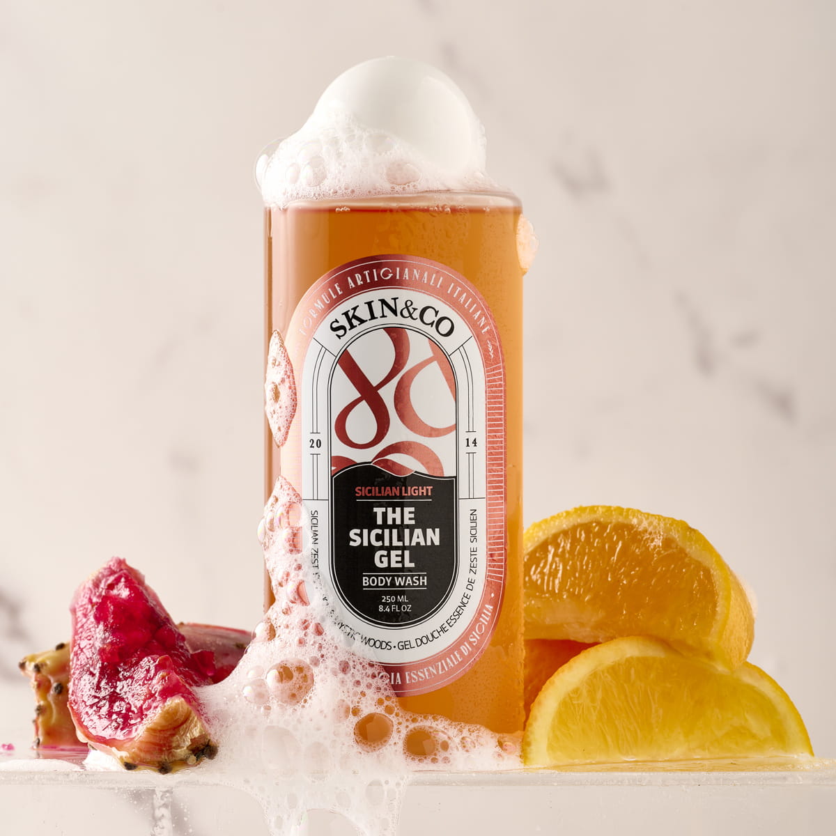 Lifestyle shot of Skin & Co The Sicilian Gel Body Wash (250 ml) with ingredients including lemons in the background
