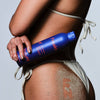 Woman in bikini holding Freaks of Nature Solar Shield SPF 20 Spray (6 oz)